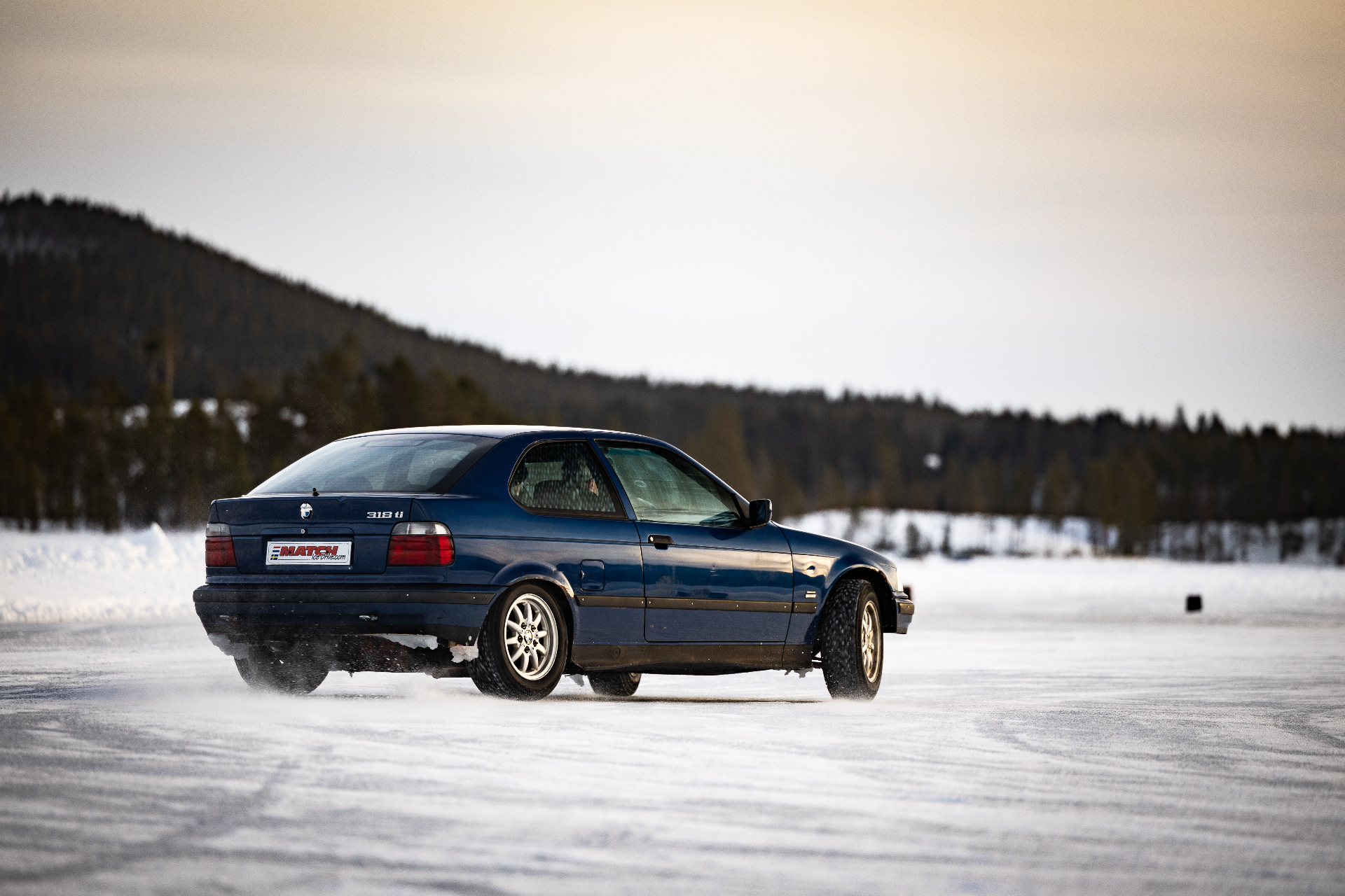 Blauwe BMW 318ti driftauto op ijsmeer